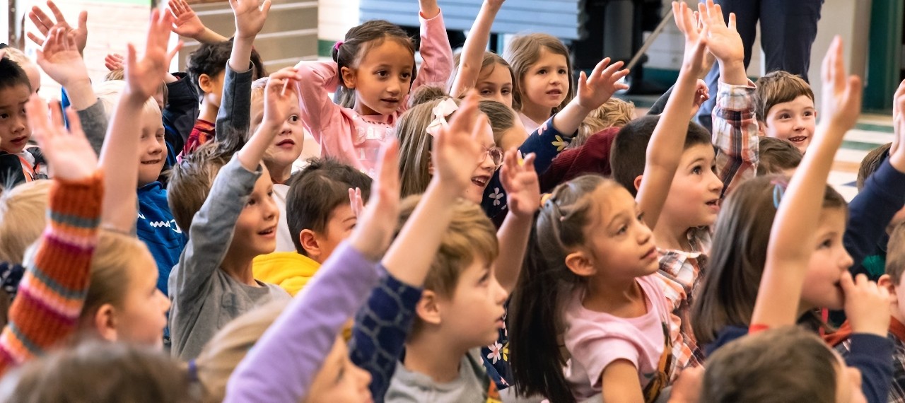 Students at Mountain View Elementary School raise their hands in class.